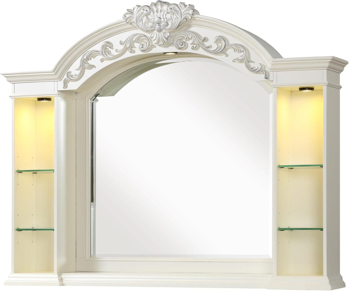 An ornate white arched wall mirror with decorative scrollwork above the mirror and built-in illuminated side shelves with glass display compartments.