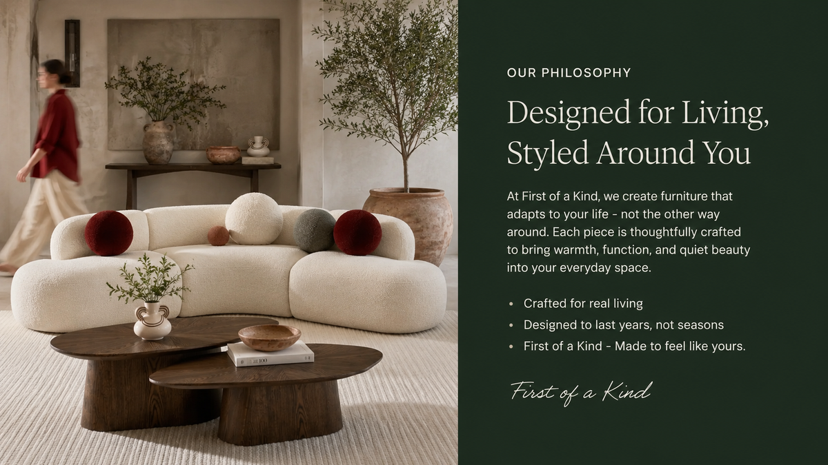 A styled interior scene shows a cream curved sectional sofa with round accent pillows in red, beige, and gray, alongside dark wood coffee tables. A person walks in the background near a console table.