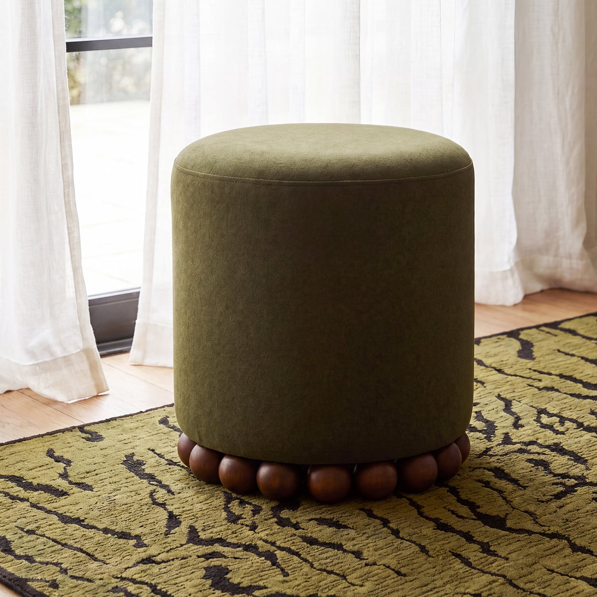 Studio product photograph of Dex round cushioned footstool