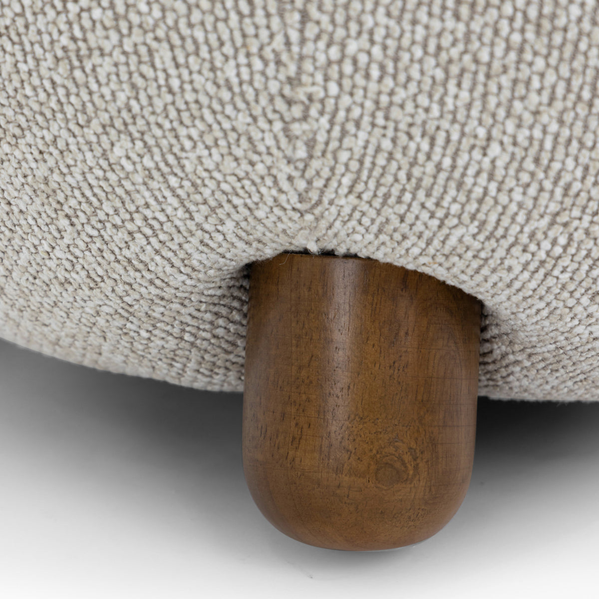 Macro shot of the spherical solid wood ball foot supporting the Pucker Accent Chair