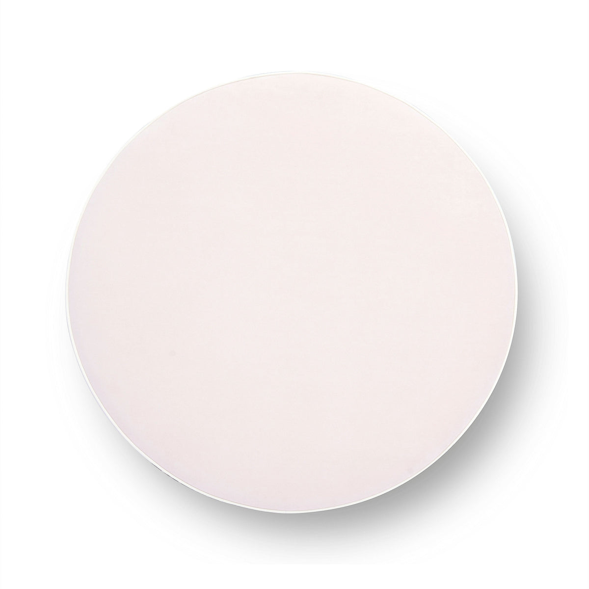 Tassy Tasseled Round Ottoman in pink velvet positioned in modern living room setup