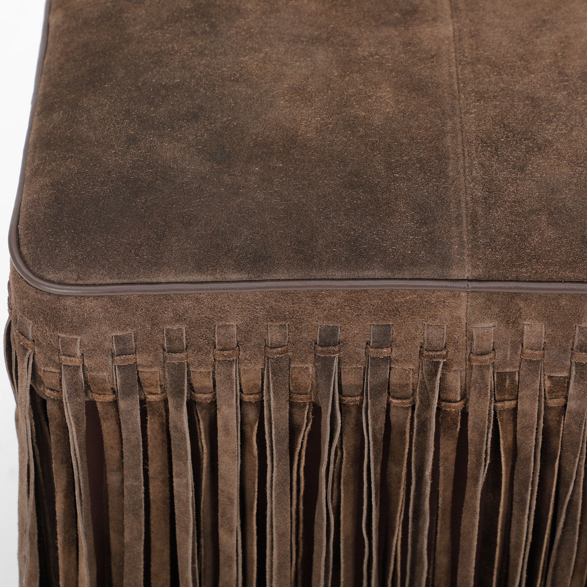 FOAK Daphne square suede fringe ottoman presented in bright natural lighting