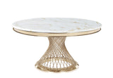 Round white marble dining table with gold veining and a sculptural gold metal base in a contemporary room.
