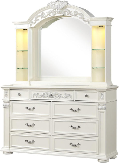 An ornate white wooden dresser with a matching arched mirror, featuring decorative carvings, six drawers, and illuminated side shelves.