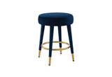 Detail shot of the circular gold footrest and tapered black stool legs.