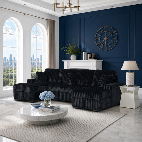 A plush black velvet sectional sofa with a chaise lounge is styled in a luxurious living room featuring a deep blue paneled wall, marble coffee table, and large arched windows.