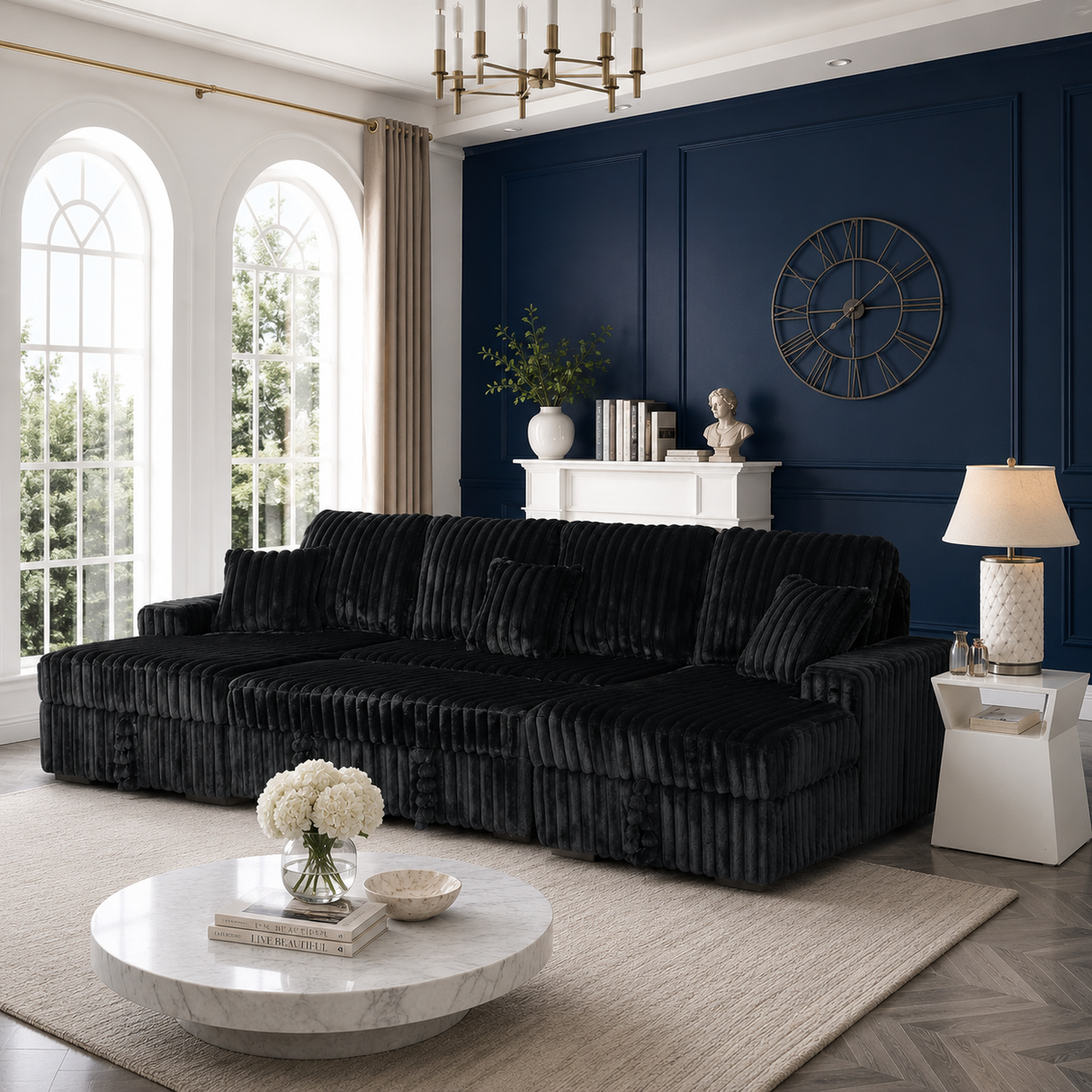 A plush black velvet sectional sofa with matching throw pillows, styled in a modern living room with a deep navy blue paneled wall, a white marble coffee table, and a beige rug.