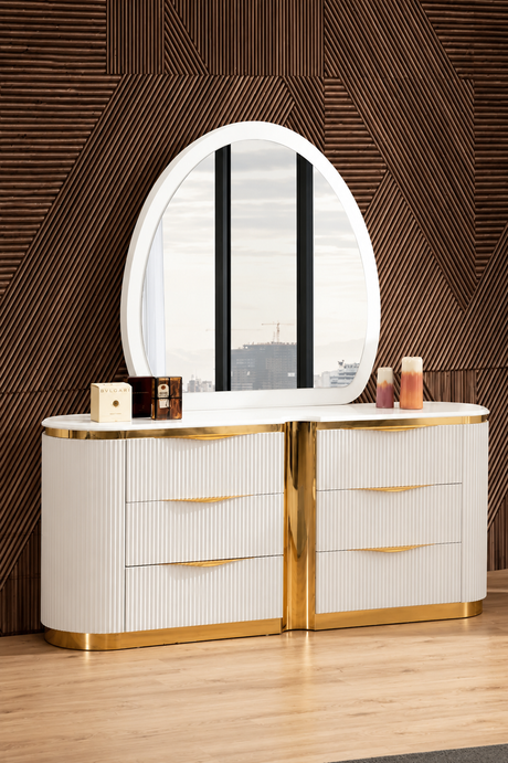 A modern white and gold vanity dresser with a large oval mirror, set against a textured brown geometric wall and light wood flooring.