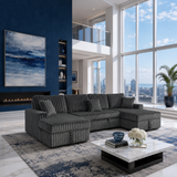 A modern gray corduroy sectional sofa with matching throw pillows in a high-rise apartment living room with a blue accent wall, fireplace, and large windows overlooking a city skyline.