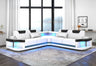 Contemporary white and black faux leather L-shaped sectional sofa with integrated LED lighting along the base.