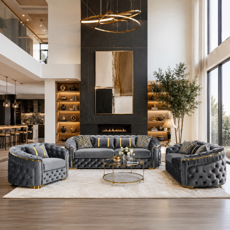 A luxury living room featuring a coordinated furniture set including a tufted gray sofa, two matching armchairs, and a round glass-top coffee table on a large cream rug. The room has a black fireplace wall, built-in wood shelving, a modern ring light, and a tall indoor tree.