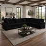 Modern living room with a black sectional sofa, coffee table, and decorative elements.