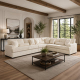 A large cream sectional sofa in a modern, sunlit living room with wood ceiling beams, a dark wood coffee table, and a textured beige rug.