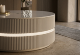 Architectural coffee table with soft halo light base in a contemporary living room setting.