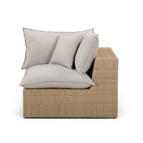 Perspective shot of black cushions resting on dark brown wicker corner unit