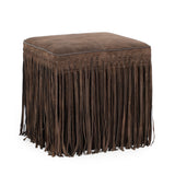 Daphne square suede fringe ottoman placed next to a sleek sofa coffee table