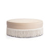 Tassy Tasseled Round Ottoman in tan velvet angled view displaying structured foam seat