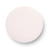 Tassy Tasseled Round Ottoman in pink velvet positioned in modern living room setup