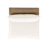 Side profile of the Cali cream cushion outdoor armless chair on a rich brown wicker base