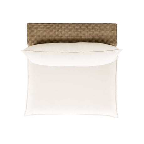 Side profile of the Cali cream cushion outdoor armless chair on a rich brown wicker base