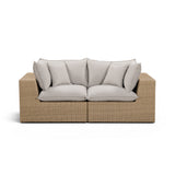 Back angled view of Cali outdoor wicker loveseat on poolside deck