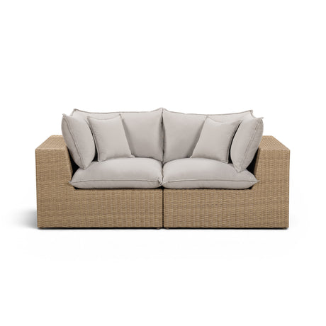 Back angled view of Cali outdoor wicker loveseat on poolside deck