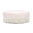 Tassy Tasseled Round Ottoman in pink velvet angled perspective highlighting contrast piping