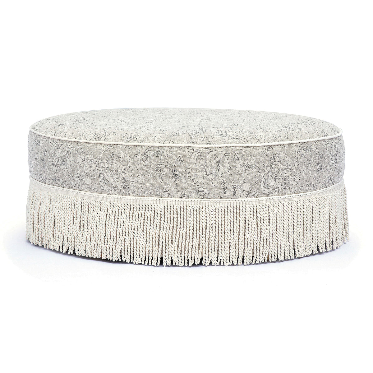 Neutral floral Tassy Round Ottoman arranged as dressing vanity stool seating