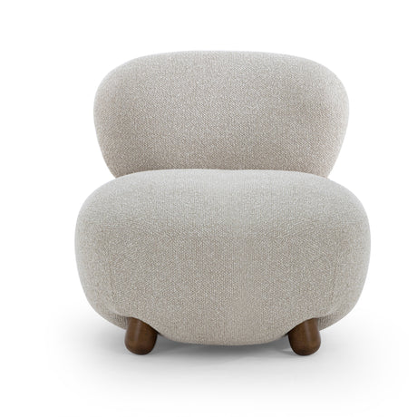 Side profile view of the Pucker Accent Chair showing curved backrest and solid wood ball feet