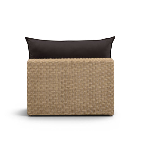 Side view of the natural wicker frame and cream outdoor seat cushion on the Cali chair