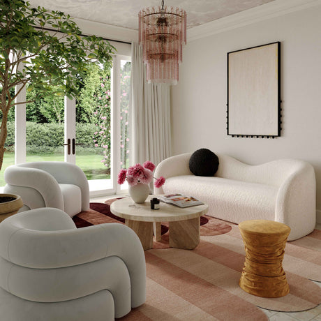 Modern living room with white furniture, a tree, and decorative elements.